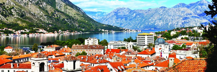 Montenegro. A view from above on the picturesque old town of Kotor with red tiled roofs and blue water of the Boka Kotor Bay on a sunny summer day (protected by UNESCO)