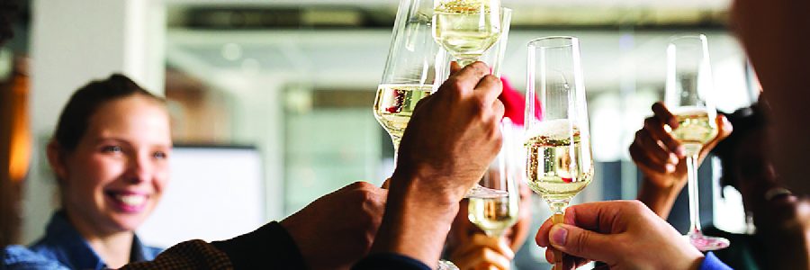 Cropped image of multi-ethnic business people toasting champagne flutes while celebrating Christmas in office