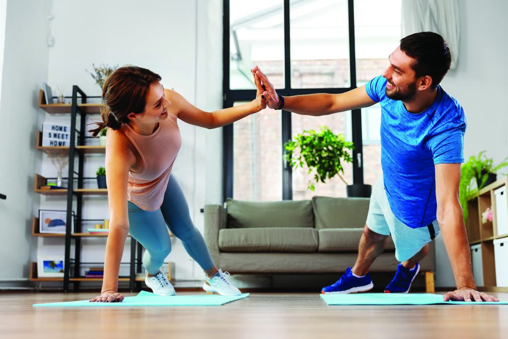 happy couple make high five in side plank at home